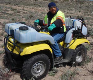 All Seasons Weed Control in Northern CA - Greg at the controls of Custom ATV sprayer with saddle tanks